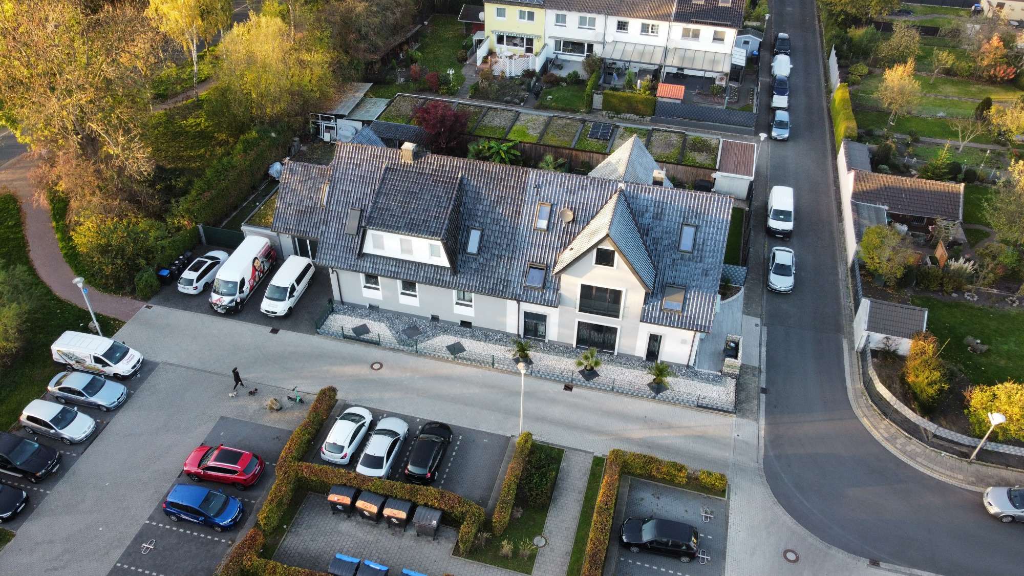 Wohnhaus mit anthrazitfarbenem Dach im Abendlicht, aus der Luft fotografiert