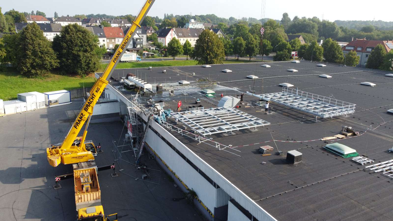 Montage einer Photovoltaikanlage auf einem großen Flachdach mit Kran
