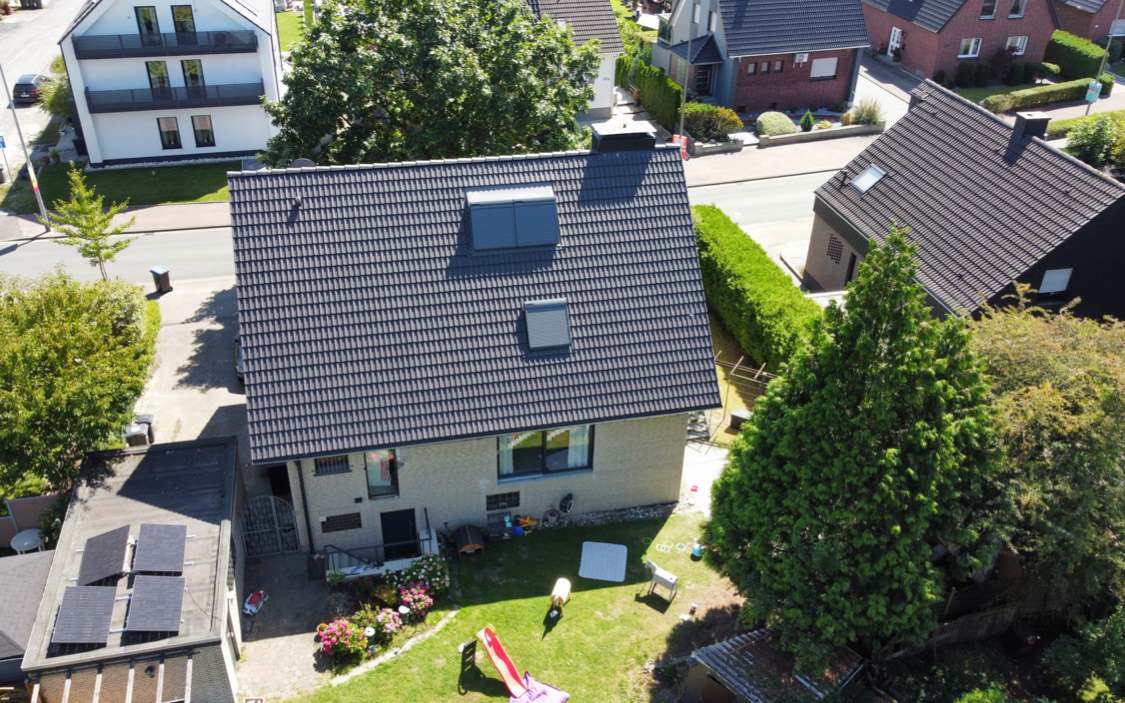 Anthrazitfarbenes Ziegeldach mit zwei Dachfenstern von oben