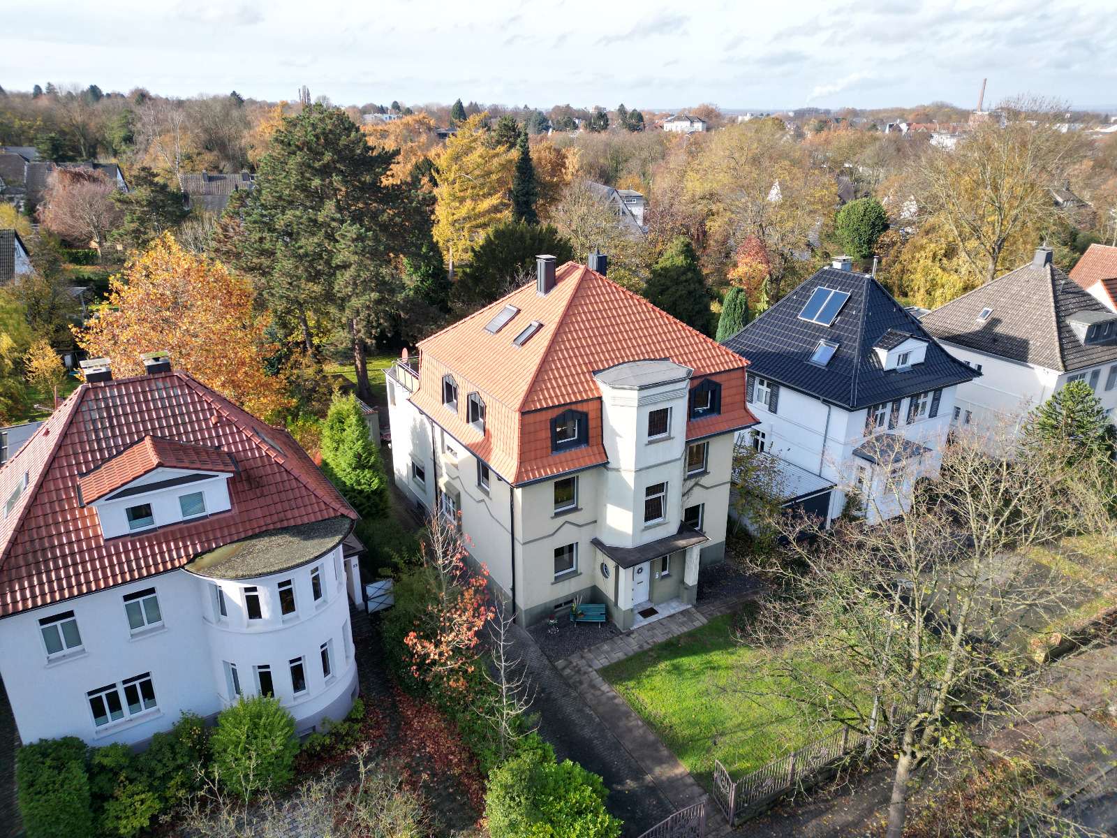 Villen mit roten und anthrazitfarbenen Ziegeldächern im Herbst, aus der Luft fotografiert